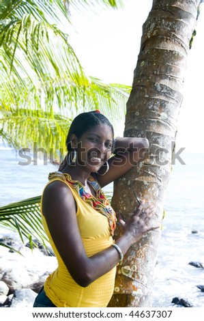 smiling native nicaragua young black woman with gold tooth portrait against coconut tree in the tropics central america Big Corn Island Nicaragua