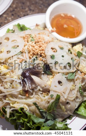 vietnamese food bun xao rice stir fried rice noodles with shredded vegetables egg crushed peanut vegetarian style mushrooms lotus root with nuoc cham sauce in bowl on side