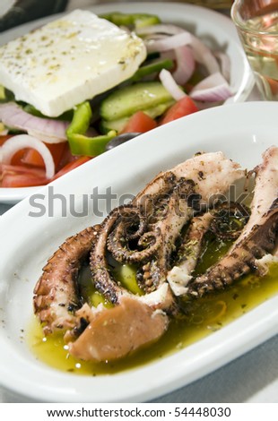 Greece taverna restaurant specialty of marinated octopus with Greek Salad and house wine as photographed in Antiparos Island Cyclades