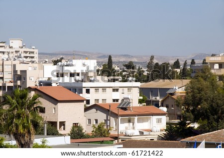 rooftop cityscape view of Larnaca Cyprus hotels condos apartments offices Mediterranean sea and mountains in distance