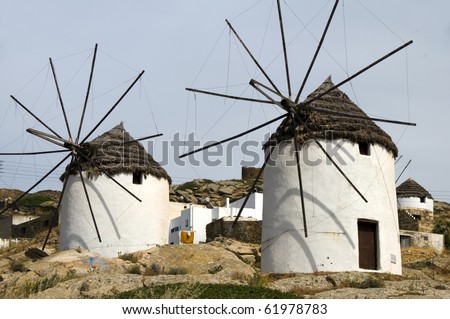 two windmills Ios Island Cyclades Greece with thatch roof and white stucco architecture horizontal