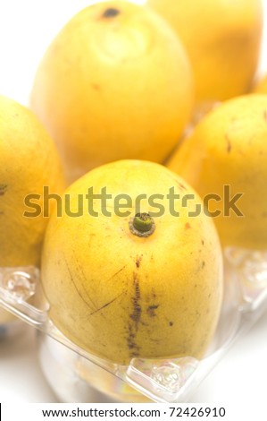 The  fresh fruit  group of Ataulfo mango also called Champagne  young baby yellow honey  manilla Adaulfo or Adolfo is a mango  from Mexico in display shipping box white background