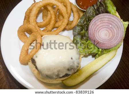 classic cheeseburger onion rings kosher pickle slice or red onion lettuce ketchup plate