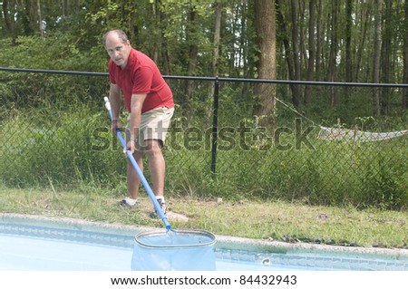 homeowner swimming pool maintenance man cleaning swimming pool skimming debris from water horizontal composition
