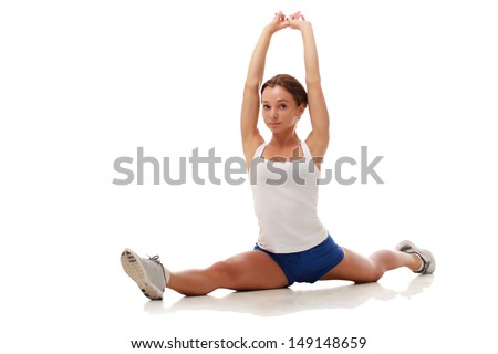 Young attractive female fitness model performing a twine, entire body, full, stretching
