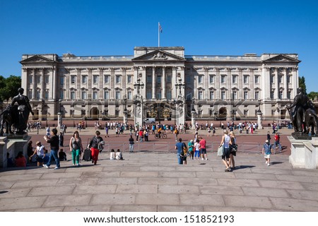 LONDON - AUGUST 1: Tourists visit Buckingham Palace on August 1, 2013 in London, England. Buckingham Palace has served as the official London residence of Britain\'s sovereigns since 1837.