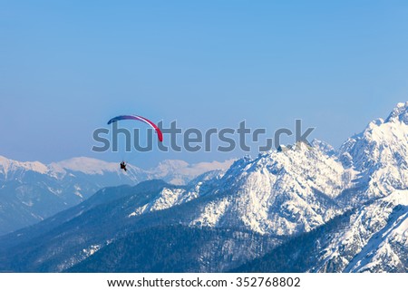 A man having fun with a para-glider over the mountains of Tarvisio, Italy