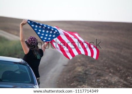 Young woman holding american USA flag. Independence Day or traveling in America concept.
