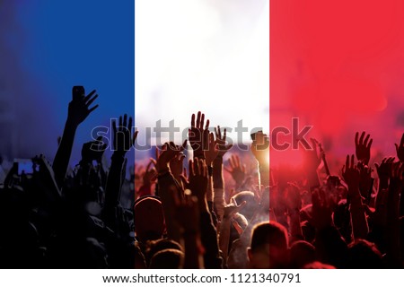 football fans supporting France - crowd in stadium with raised hands against french flag