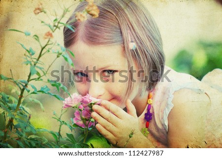 Vintage portrait of a cute little girl smelling a flower
