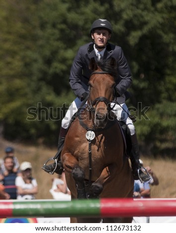SALICEA, ROMANIA - SEPTEMBER 9: An unidentified competitor jumps with his horse at the Napoca Cup Sport Horse, September 9, 2012 in Salicea, Romania