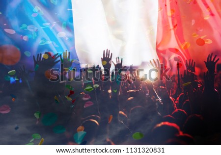 football supporters with raised hands against France flag - crowd in stadium celebrating victory