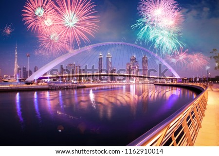 fireworks display over Dubai Downtown skyscrapers and the newly built Tolerance bridge as viewed from the Dubai water canal.