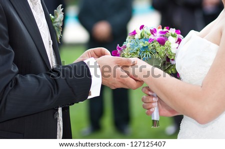 Hands and rings on wedding bouquet