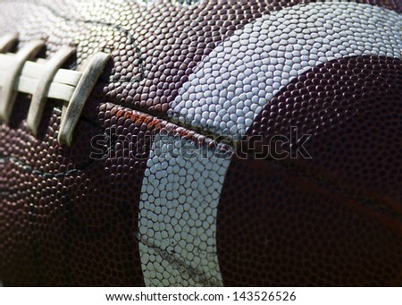 Close up of an american football against a black background