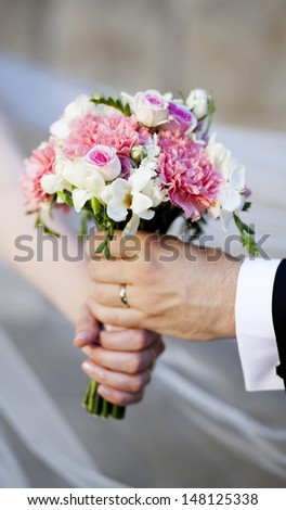 Groom handing over wedding bouquet