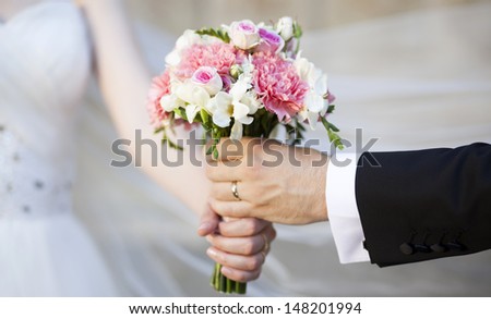 Groom handing over wedding bouquet