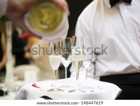 champagne being poured into a champagne flute by waitstaff