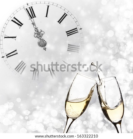 Glasses with champagne against holiday lights and clock close to midnight