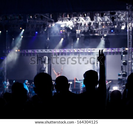 Cheering crowd in front of bright colorful stage lights