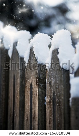 snow on a wooden fence
