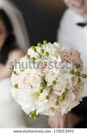 Bride and groom holding beautiful white wedding bouquet