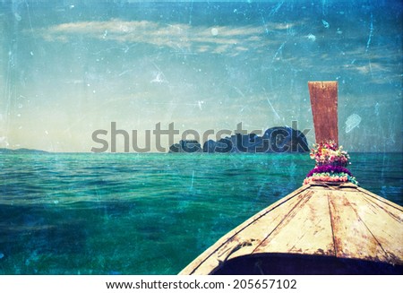 Vintage holiday background - traditional longtail boat heading to an island