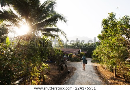 Backpacker woman leaving a jungle resort in Khao Sok, Thailand