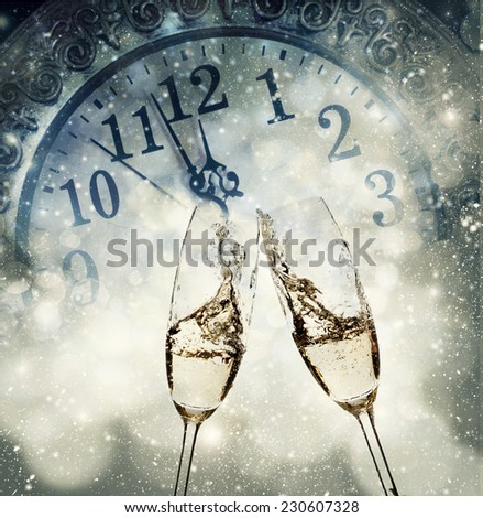 Toasting with champagne against fireworks and clock close to midnight