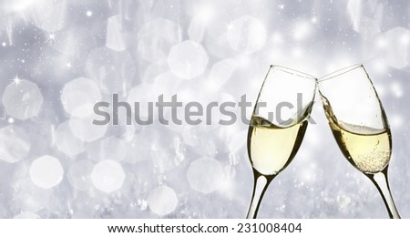 Glasses with champagne against sparkling holiday background