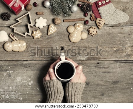Christmas decorations, home made ginger bread and woman\'s hand on mulled wine on rustic wooden background