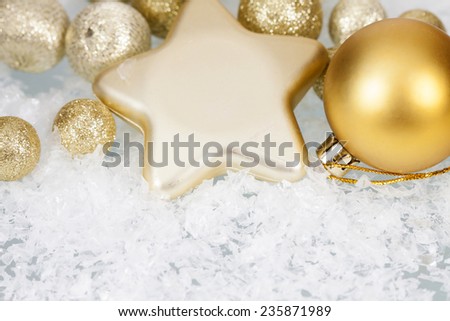 Golden Christmas balls and star on icy background