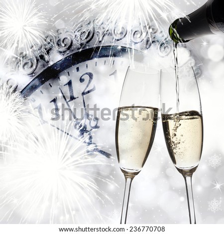 New Year\'s - toasting with champagne glasses against fireworks and clock close to midnight