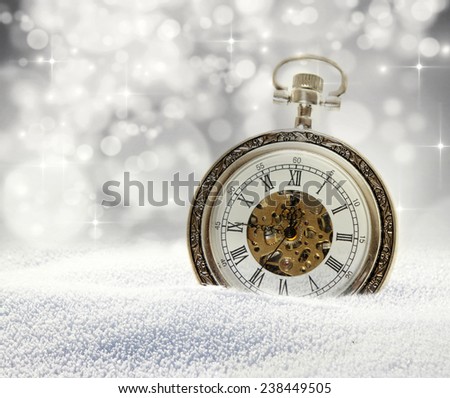 New Year\'s at midnight - old clock in snow on colorful bokeh background