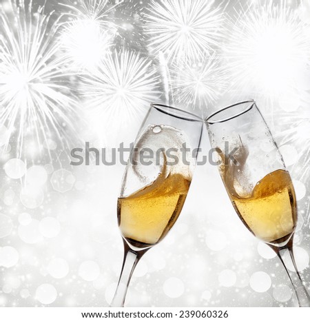 New Year's - toasting with champagne glasses against fireworks and holiday lights