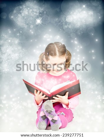 Happy child reading magic book - Christmas concept