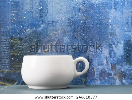 Coffee cup on a rainy day on window background