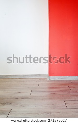 Empty room with red wall and wooden floor