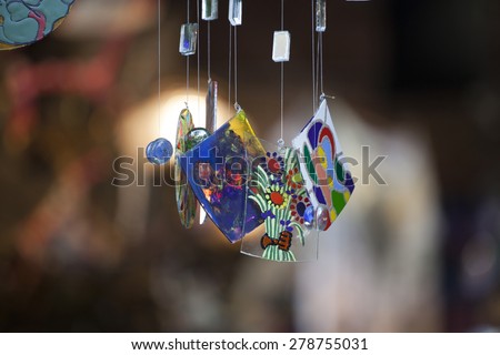 Colorful glass wind chime hanging outside, shallow focus
