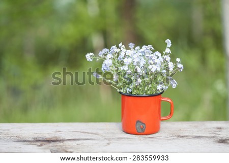 Summer background with forget me not flowers in a jar on wooden background
