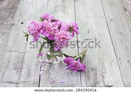 Pink peonies on wooden background