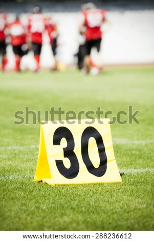 American football game. Yard markers with out of focus players in the background