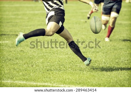Rugby player kicking hard the oval ball - sports concept, retro style photo