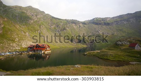 Carpathian mountain landscape. Lake and house on foreground.