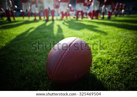 american football on stadium with out of focus players in the background - sport concept