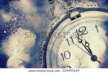 New Year\'s at midnight - Old clock with fireworks and holiday lights