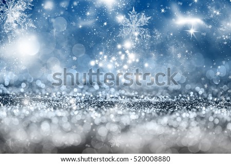 Magic blue holiday abstract glitter background with blinking stars and falling snowflakes. Blurred bokeh of Christmas lights.
