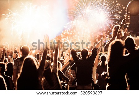 cheering crowd watching fireworks at New Year - holiday celebration background