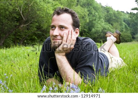Happy young man laying in grass