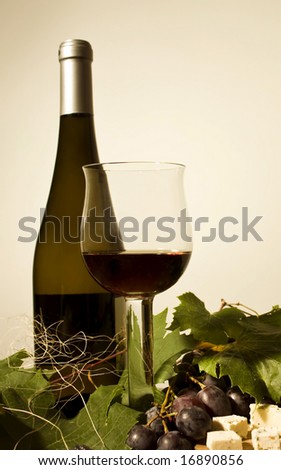 Bottle and cup of wine with grapes an cheese